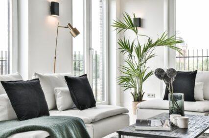 Woonkamer met witte bank en lampen